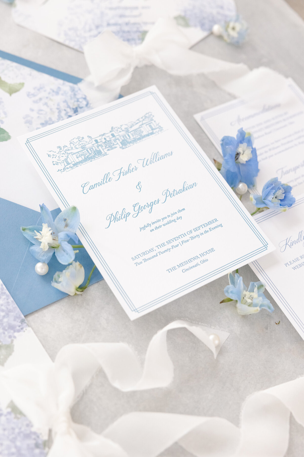 bright light and airy wedding photo of bride and groom rings and invitation