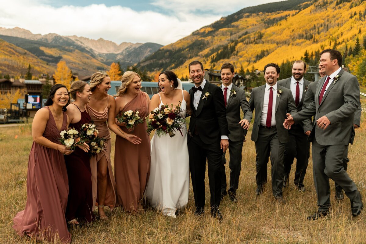 Bride and Groom celebrate with their bridal party in burgundy and pink dresses.