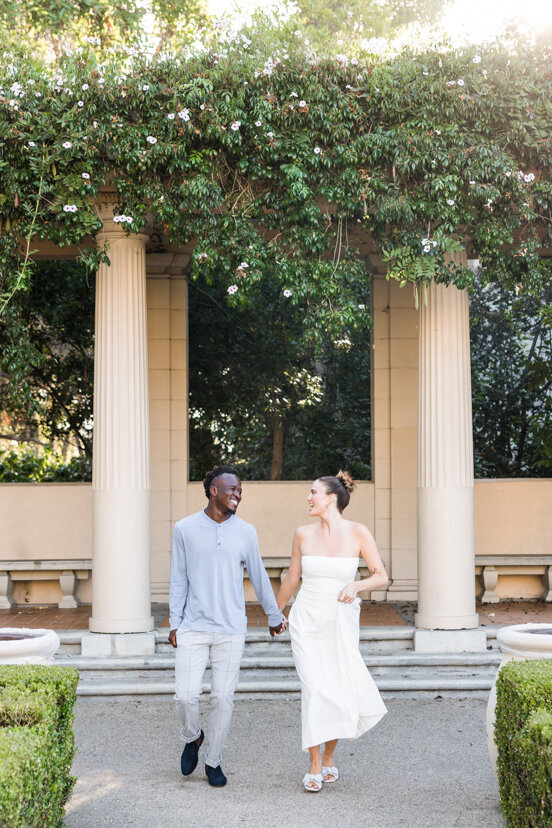 engaged-couple-walking-in-Alcazar-Garden-balboa-park-san-diego