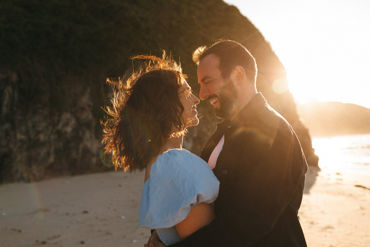 Backlit with flare photograph of a couple on the beach in west Cornwall