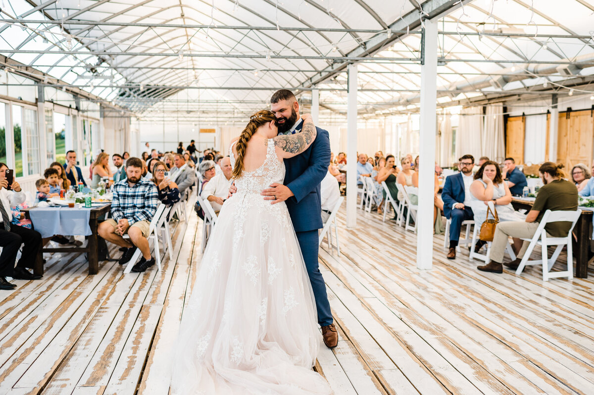 bride and groom holding each other as they dance for their first dance at their indoor wedding reception hall at Shenandoah wedding venue