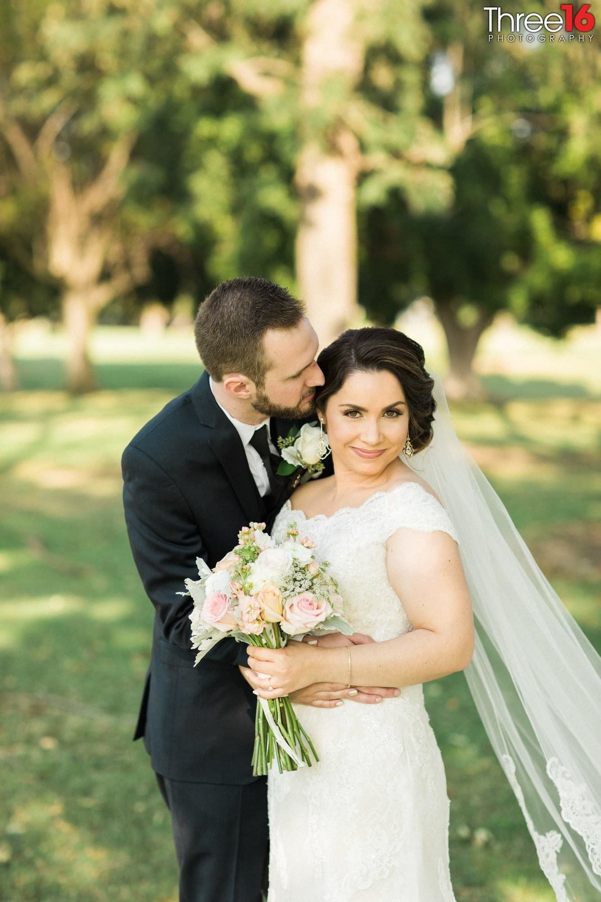 Groom whispers into his Bride's ear during the photo session
