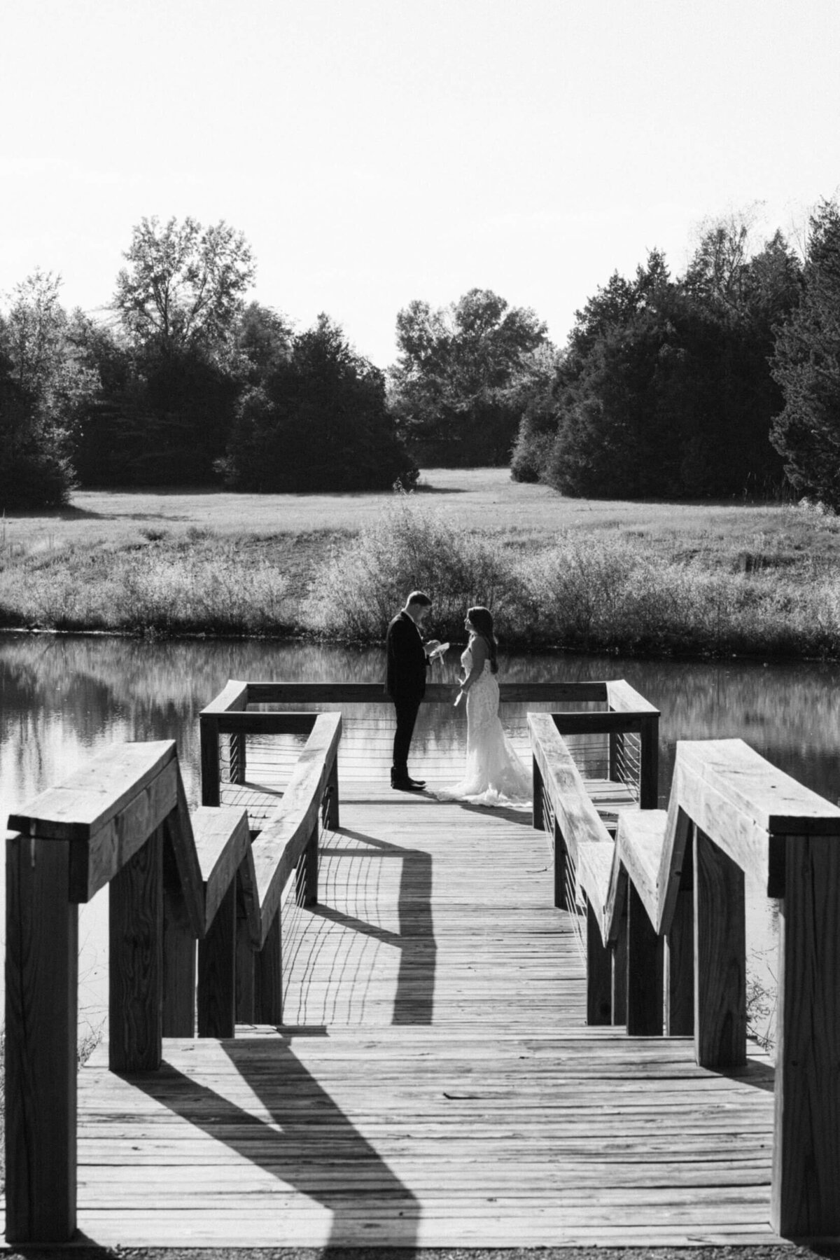 A black and white wedding photo of a bride and groom during their first look