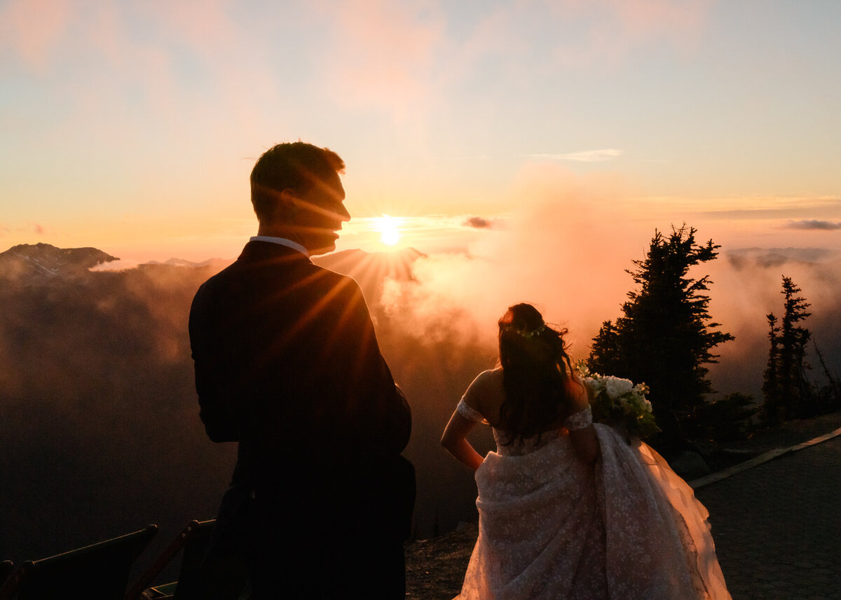 after eloping in washington state,  a bride and groom explore in their wedding attire as the sun sets