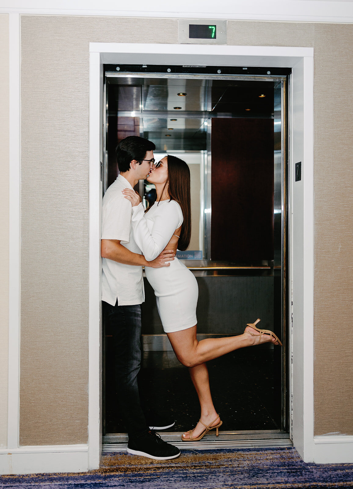 Rebecca and Graysen share a romantic kiss inside the elevator of Marriott Hotel Fort Lauderdale, a cinematic and intimate moment from their Florida Keys engagement session.
