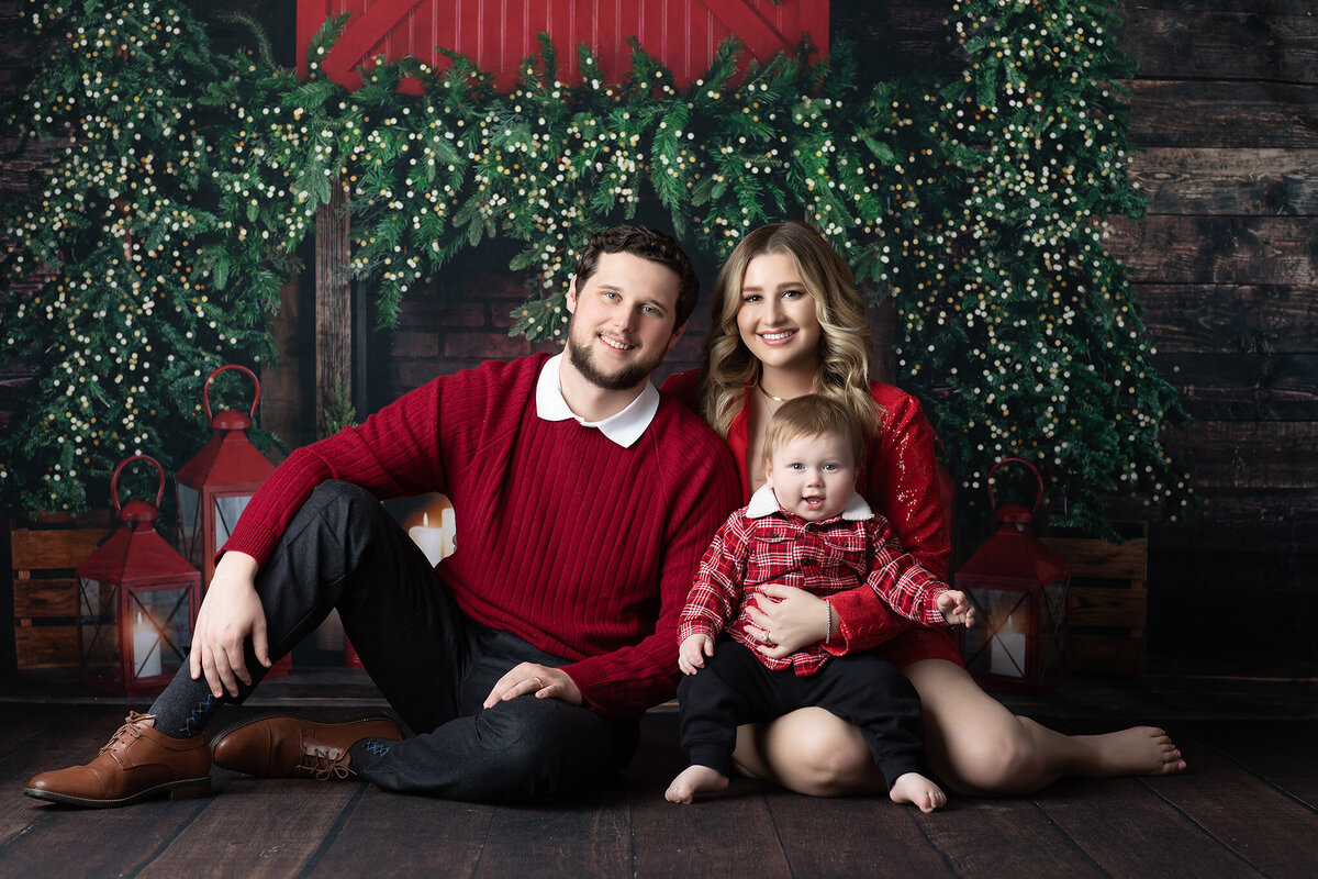 A joyful family in festive attire, captured by a Dallas family photographer, posing with a holiday backdrop.