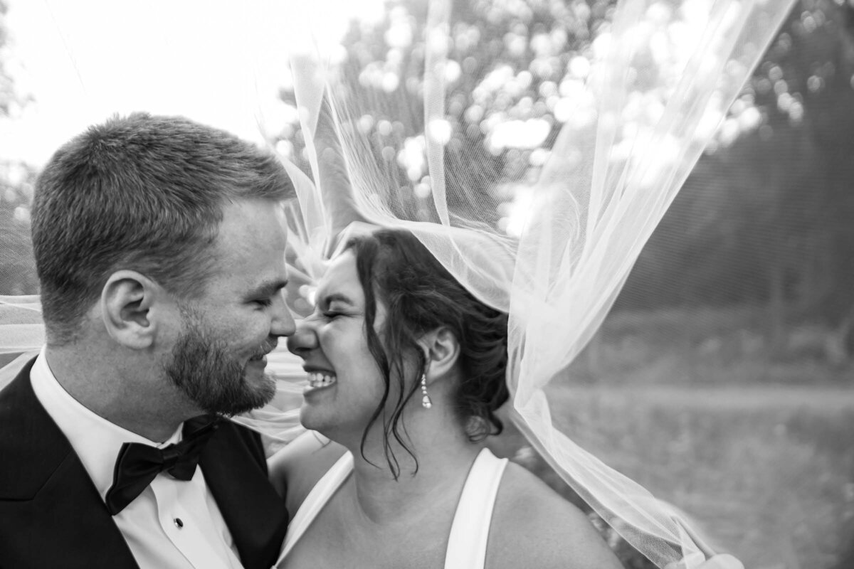 newlyweds-laughing-under-veil-black-and-white