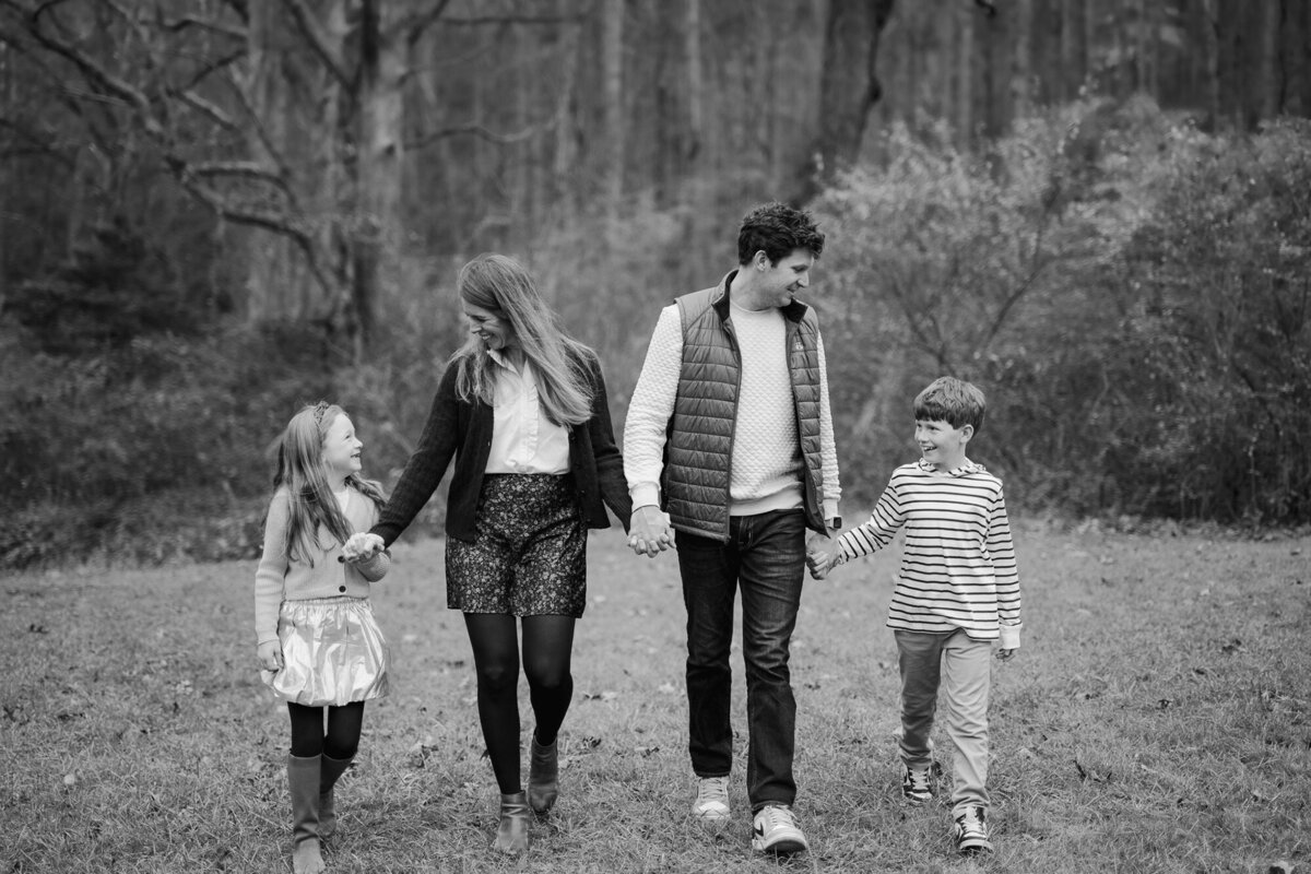 Family of four holding hands walking 