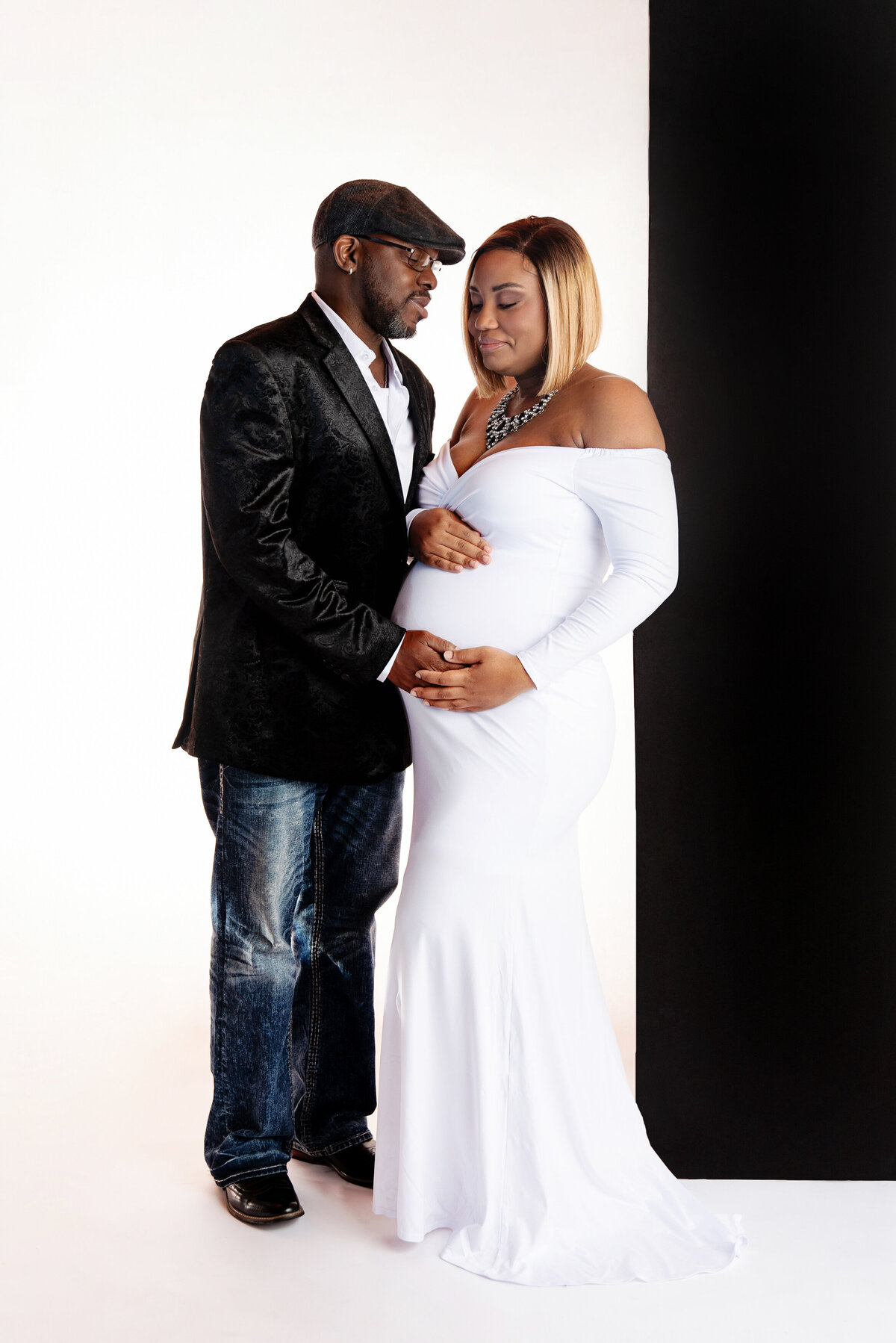 st-louis-maternity-photographer-expecitng-mom-and-dad-in-on-white-backdrop-with-black-wall