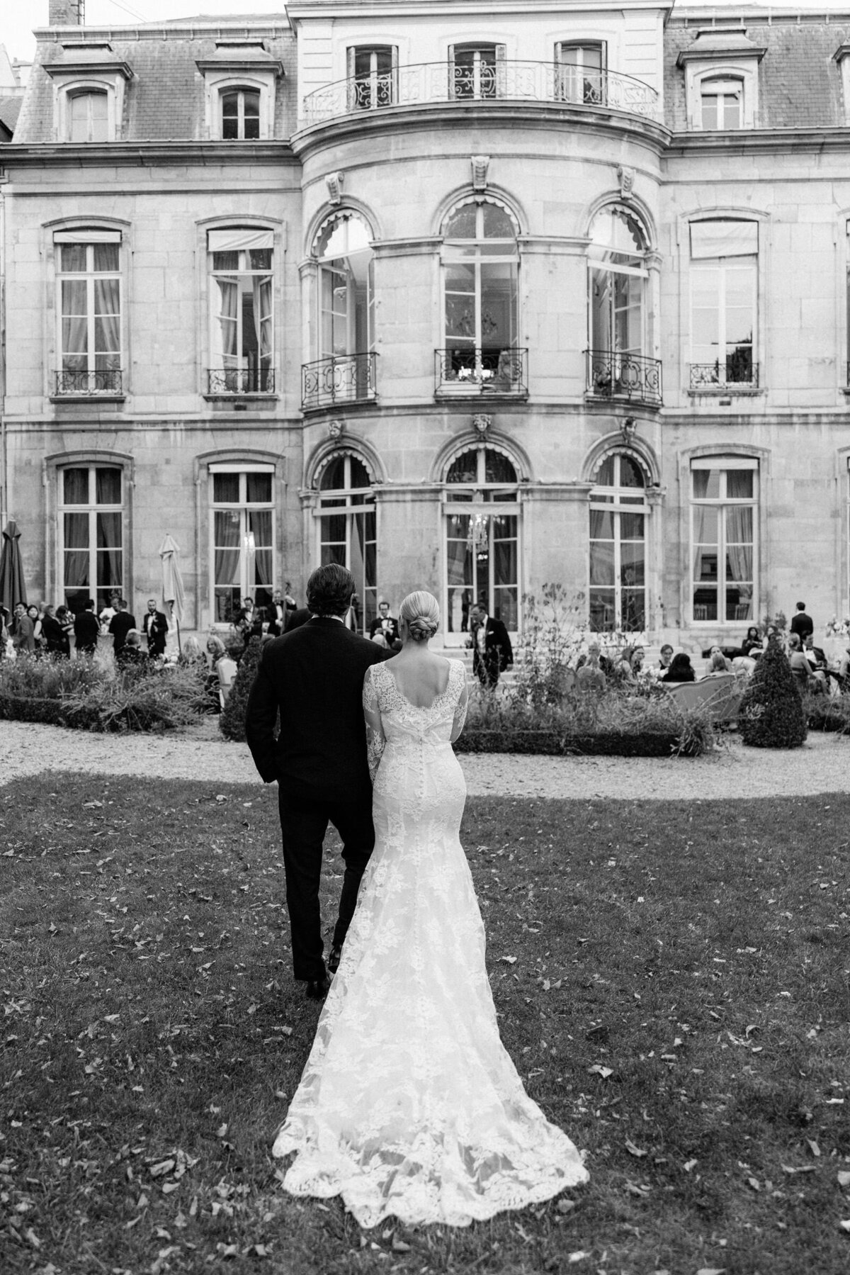 Couple walking away holding hands at the gardens of Maison de l'Amerique Latine.