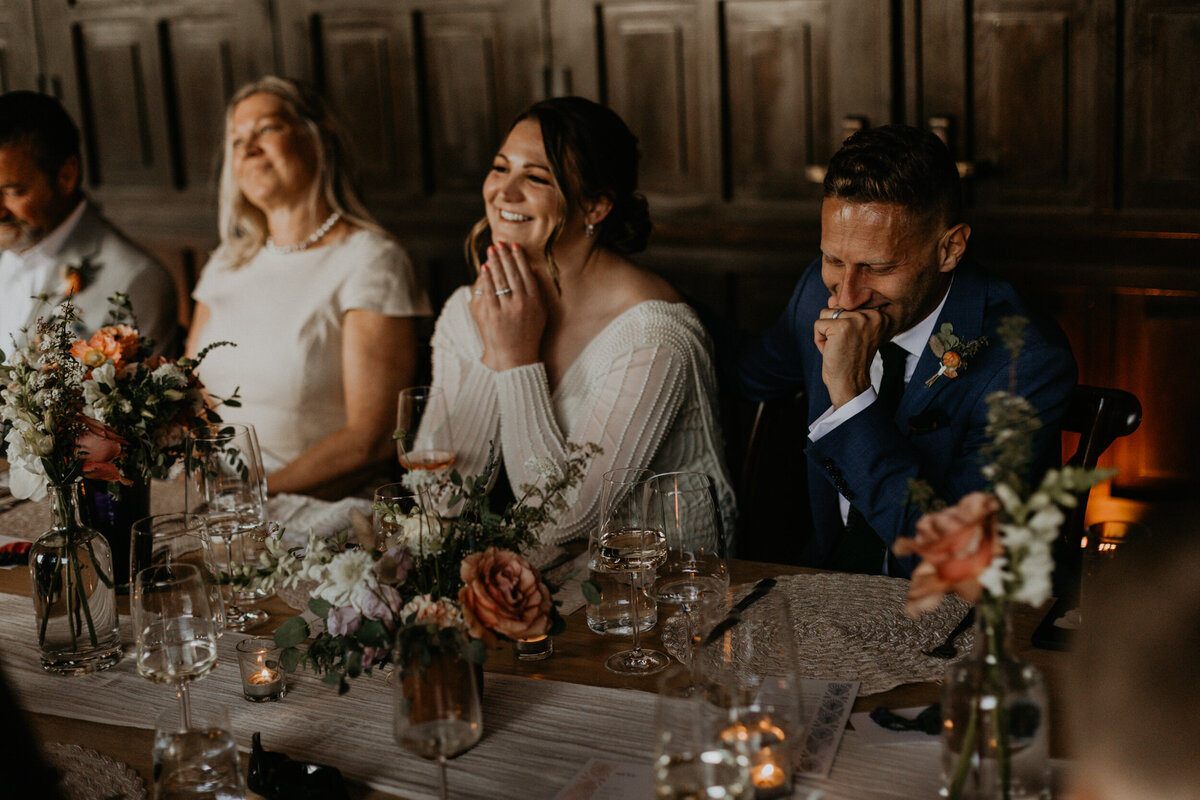 emotional shot of speeches at a newlyweds intimate wedding reception dinner