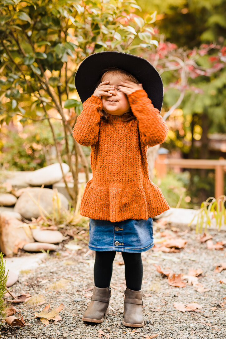 Little girl playing peek-a-boo during her portrait session in Seattle WA.