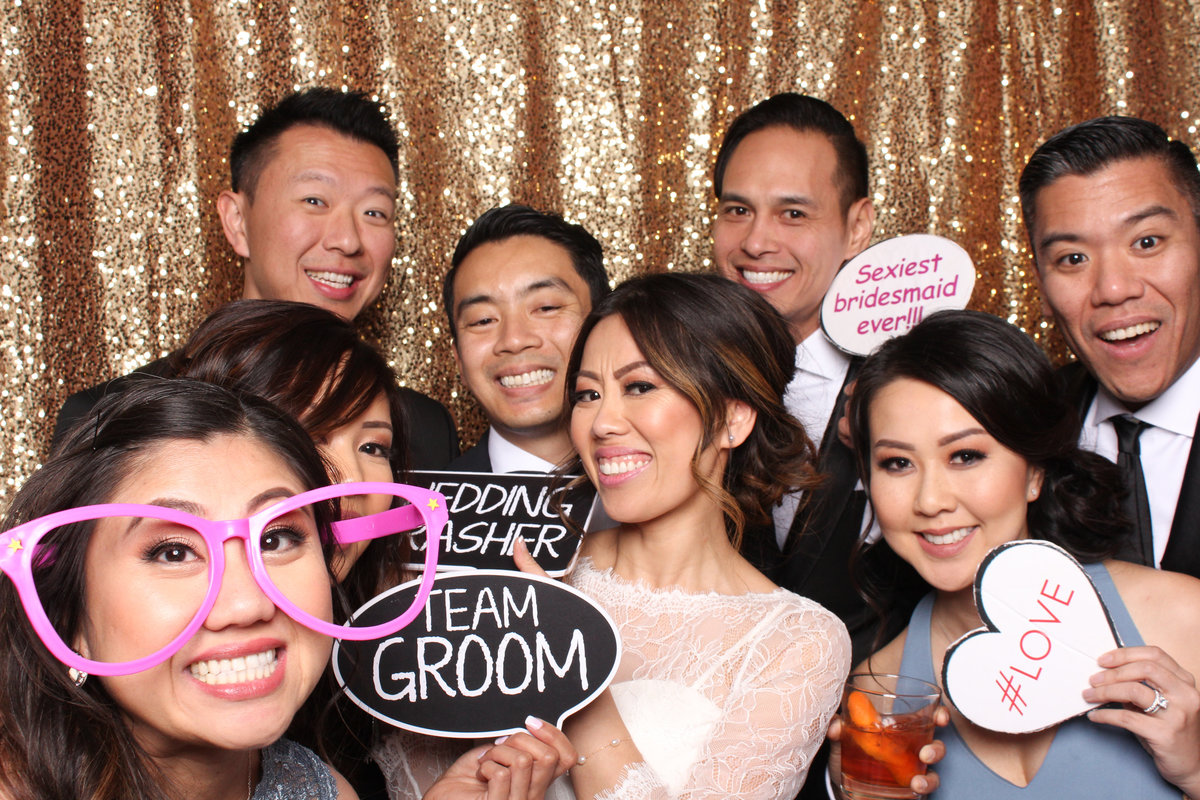 Group of friends squeeze in for a photo in the photo booth