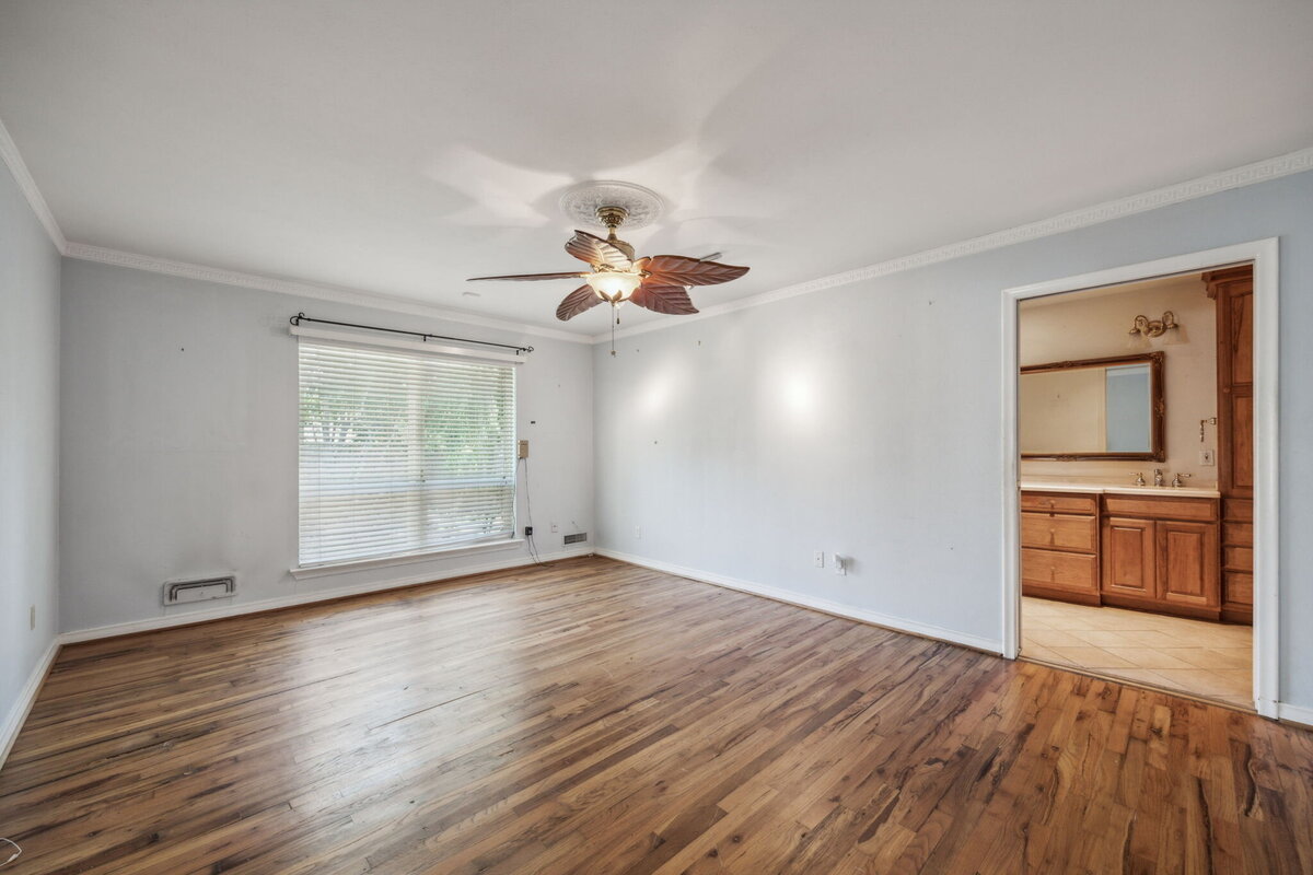 14214_edgecrest_dr_dallas_tx_primary_bedroom_-hardwood_floors_large_window_and_ensuite_bathroom_access-_haven_realty_group