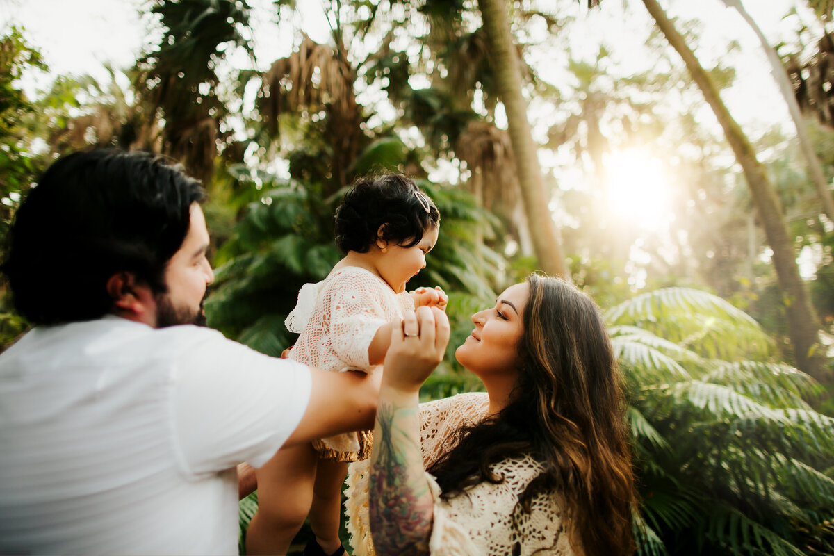 colorful greenery with a family of 3 dressed in boho clothing at sunset time