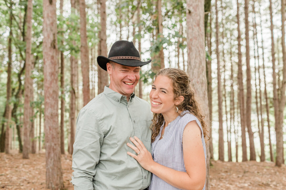couple hugging and laughing in the woods