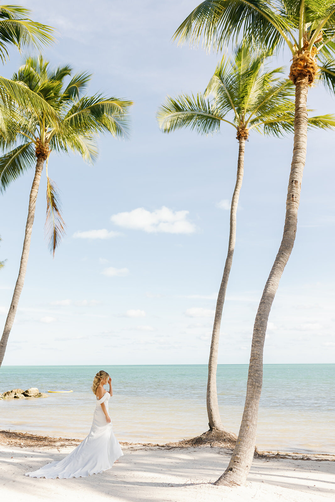Monica gracefully walks along the beach under swaying palm trees at Casitas at Cheeca, moments before seeing Austyn.