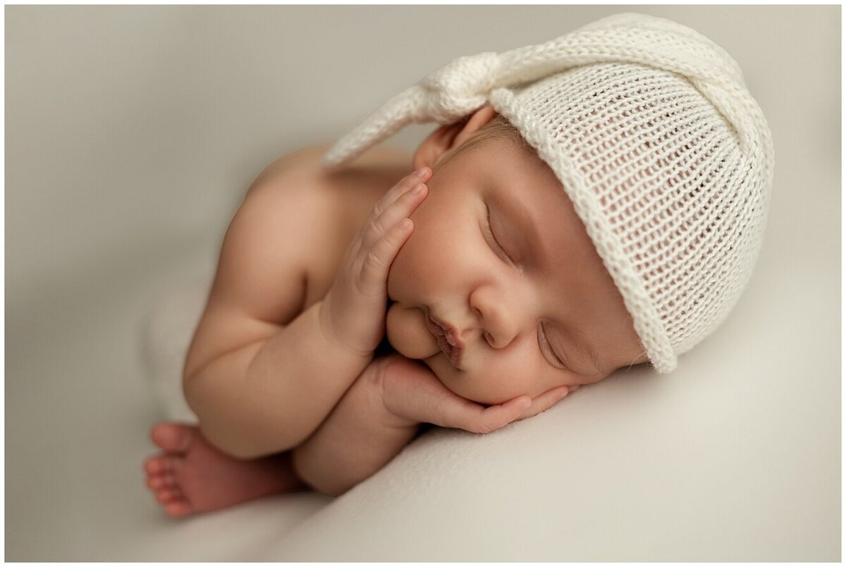 Cute newborn pose head in hands