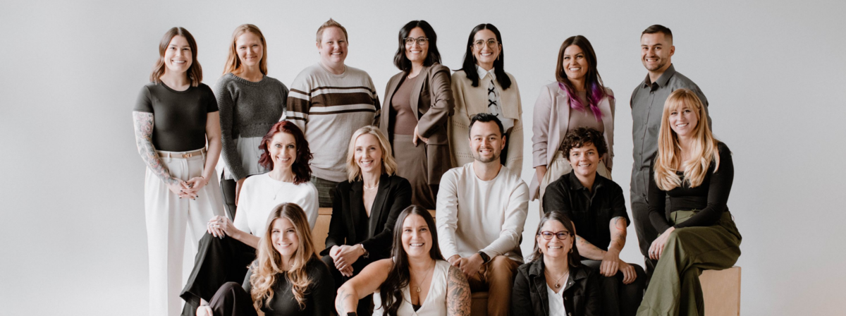 Peak Interactive Wellness team group photo at their Denver and Greenwood Village therapy practice, featuring 15 staff members smiling together in casual-professional attire.