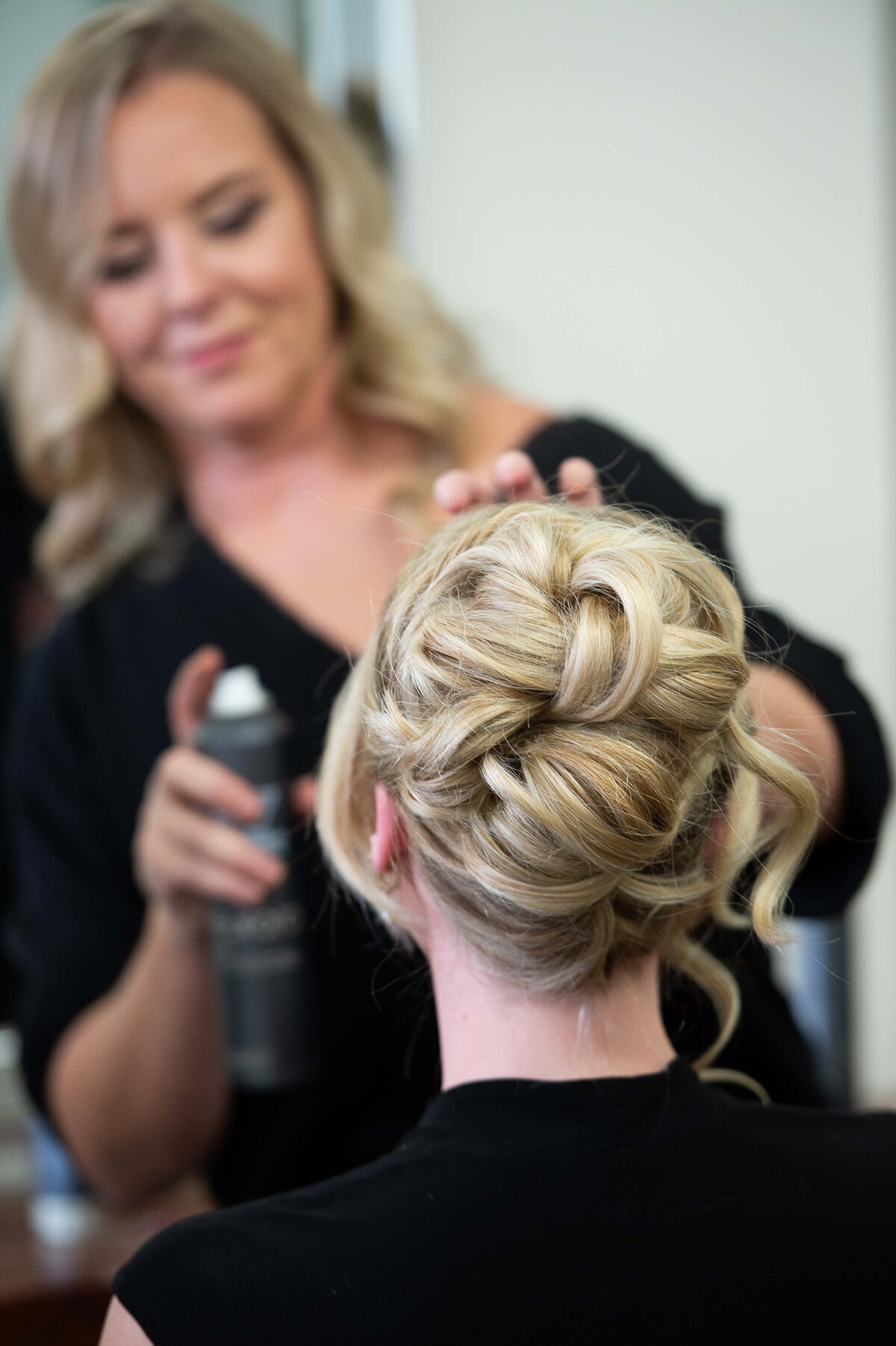 Ottawa branding photography of a stylist at Richardson Hair Design setting and spraying a blonde bridal updo.  Captured by JEMMAN Photography