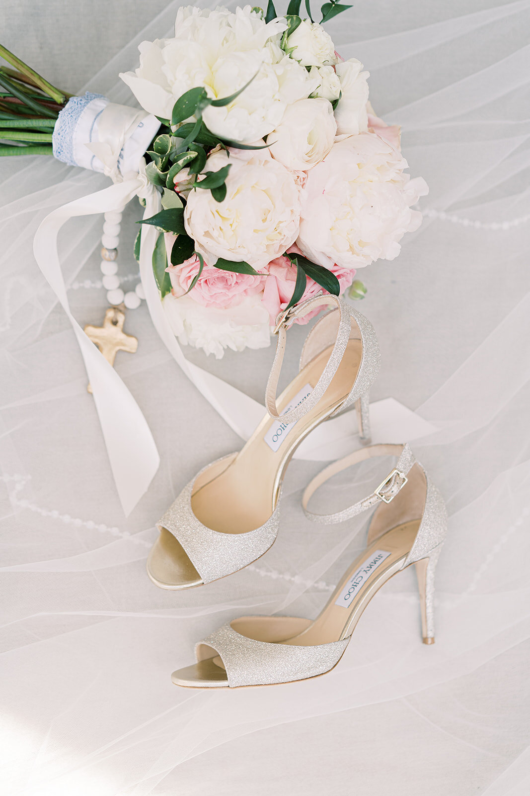 cream bridal shoes with a bouquet of white and pink flowers