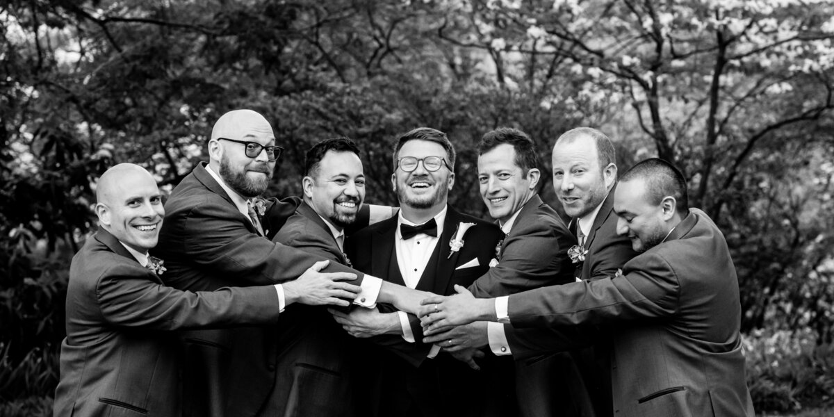 Groomsmen enjoying a laugh behind the art museum in philadelphia