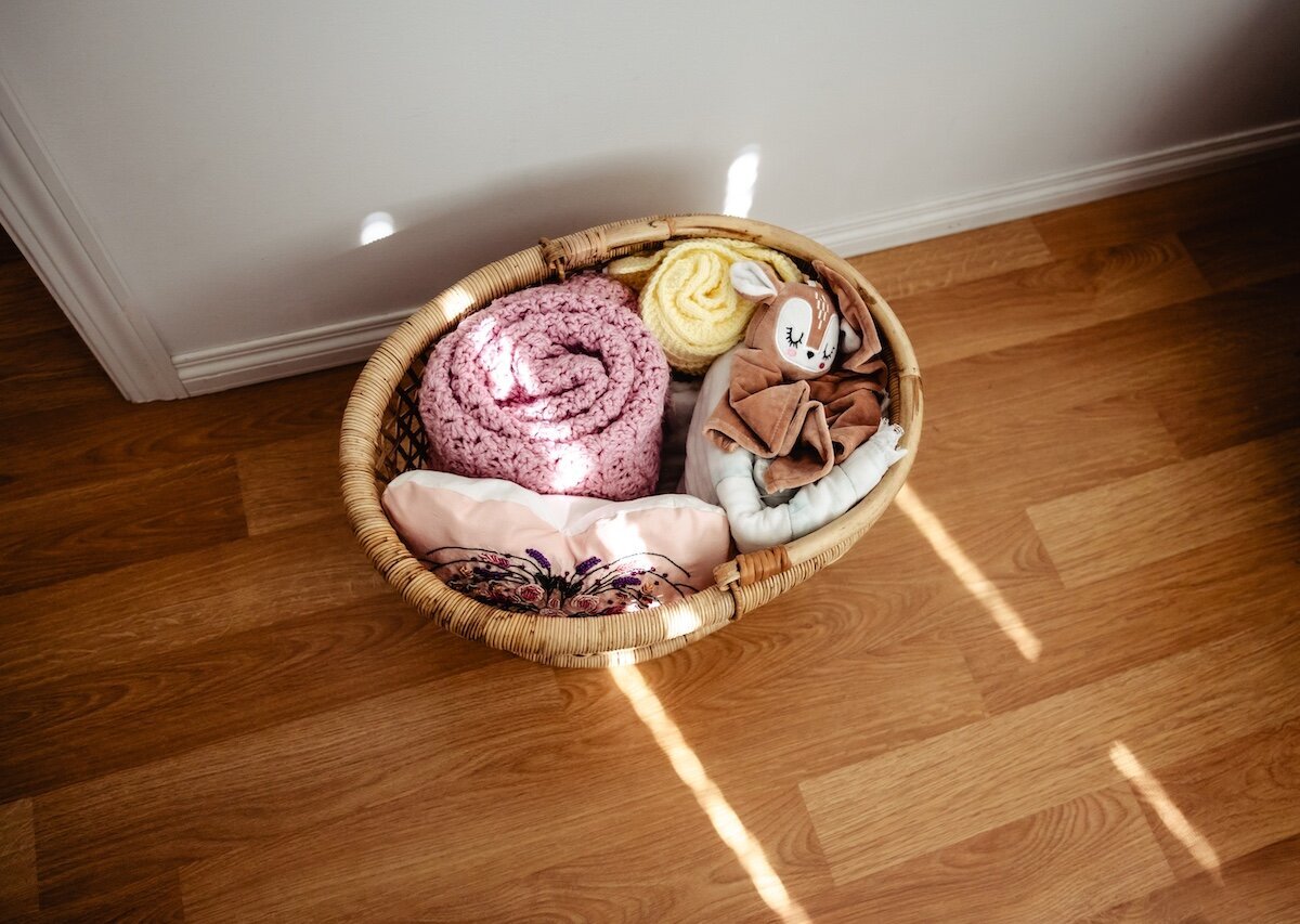 A basket holding newborn baby blankets rolled up