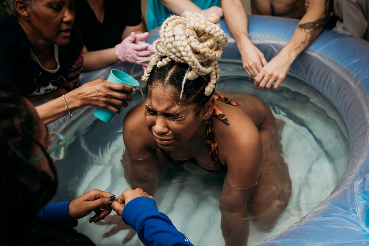 woman in labor pushing baby in birth pool