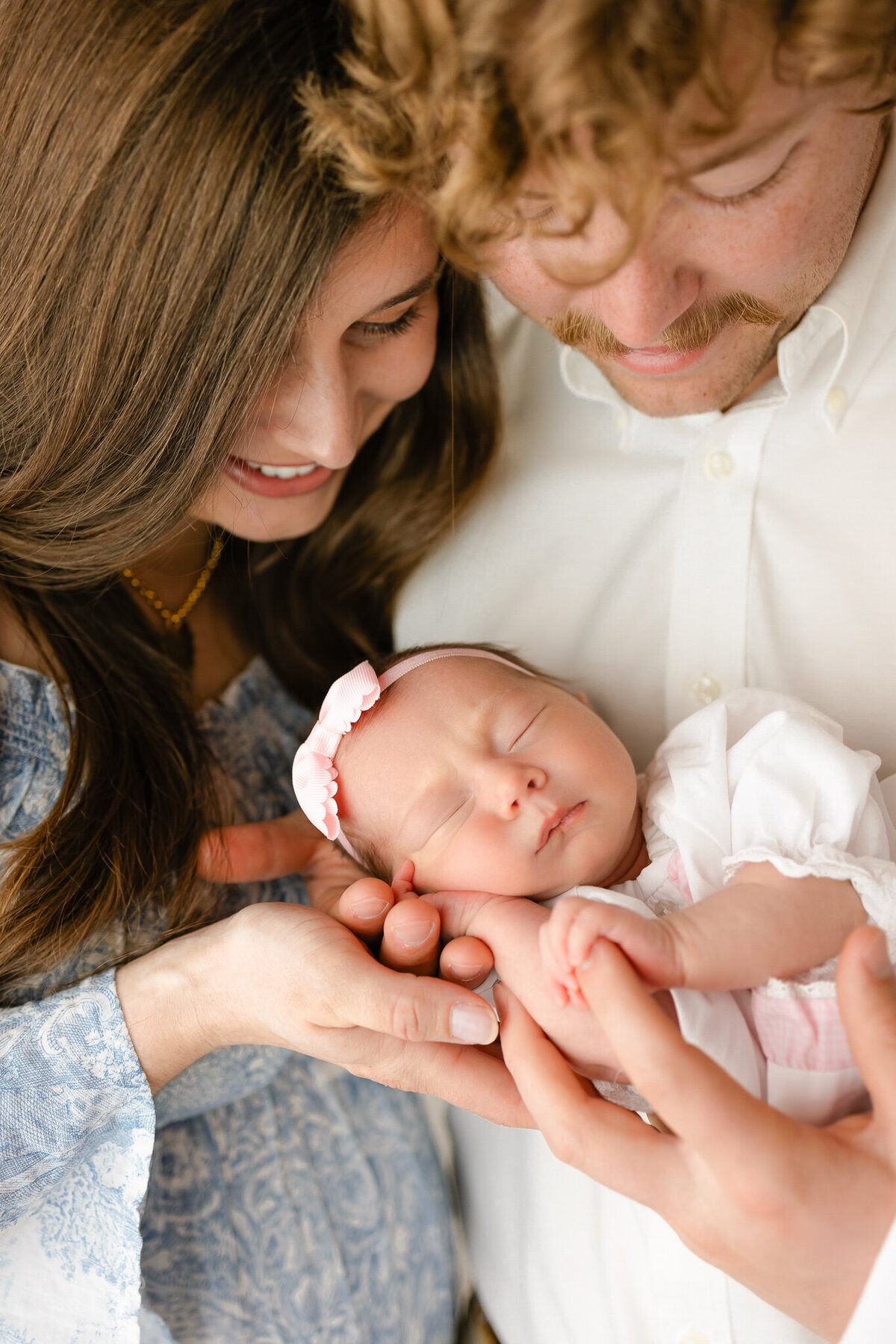 New family of 3 loving and smiling at their little girl