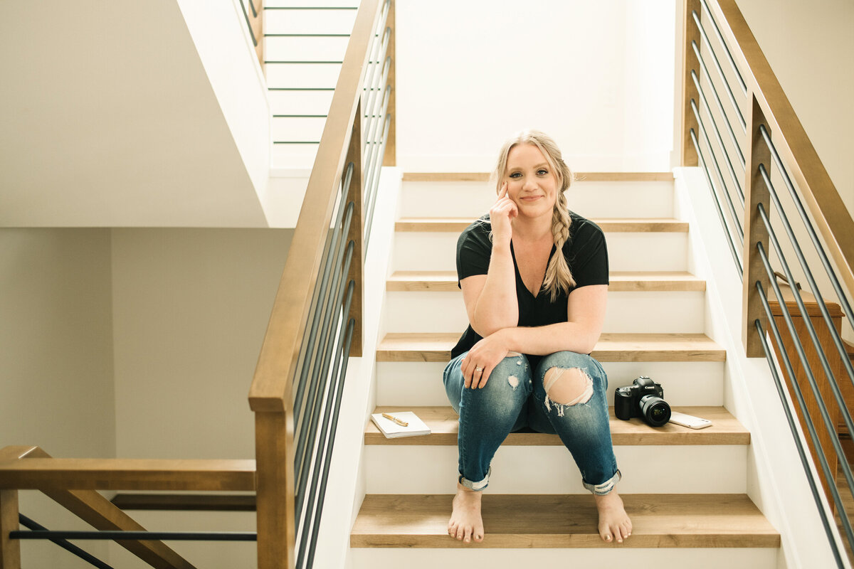 Jen isackson sitting on stairs with camera