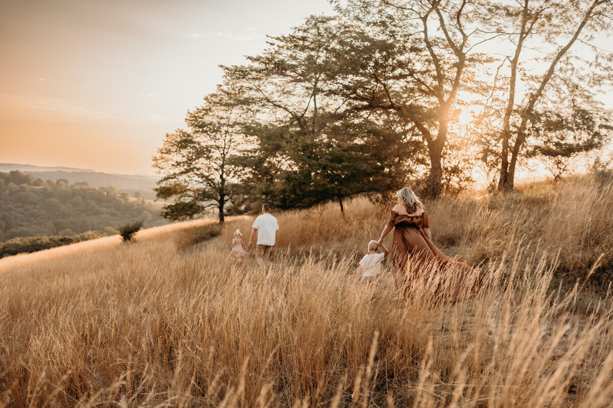 Family walking in grass boho field in Allentown Pennsylvania at sunset
