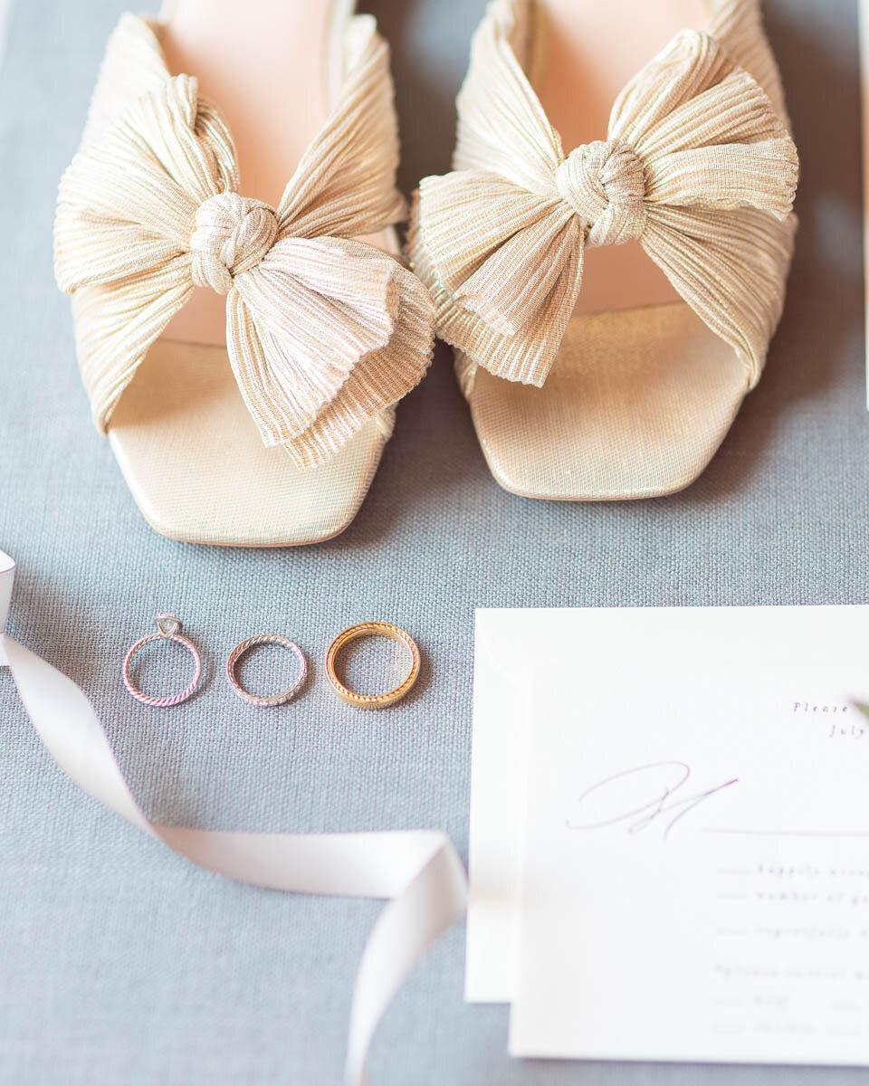 Wedding shoes and rings photographed during a wedding at Saltwater Farms Vineyards.
