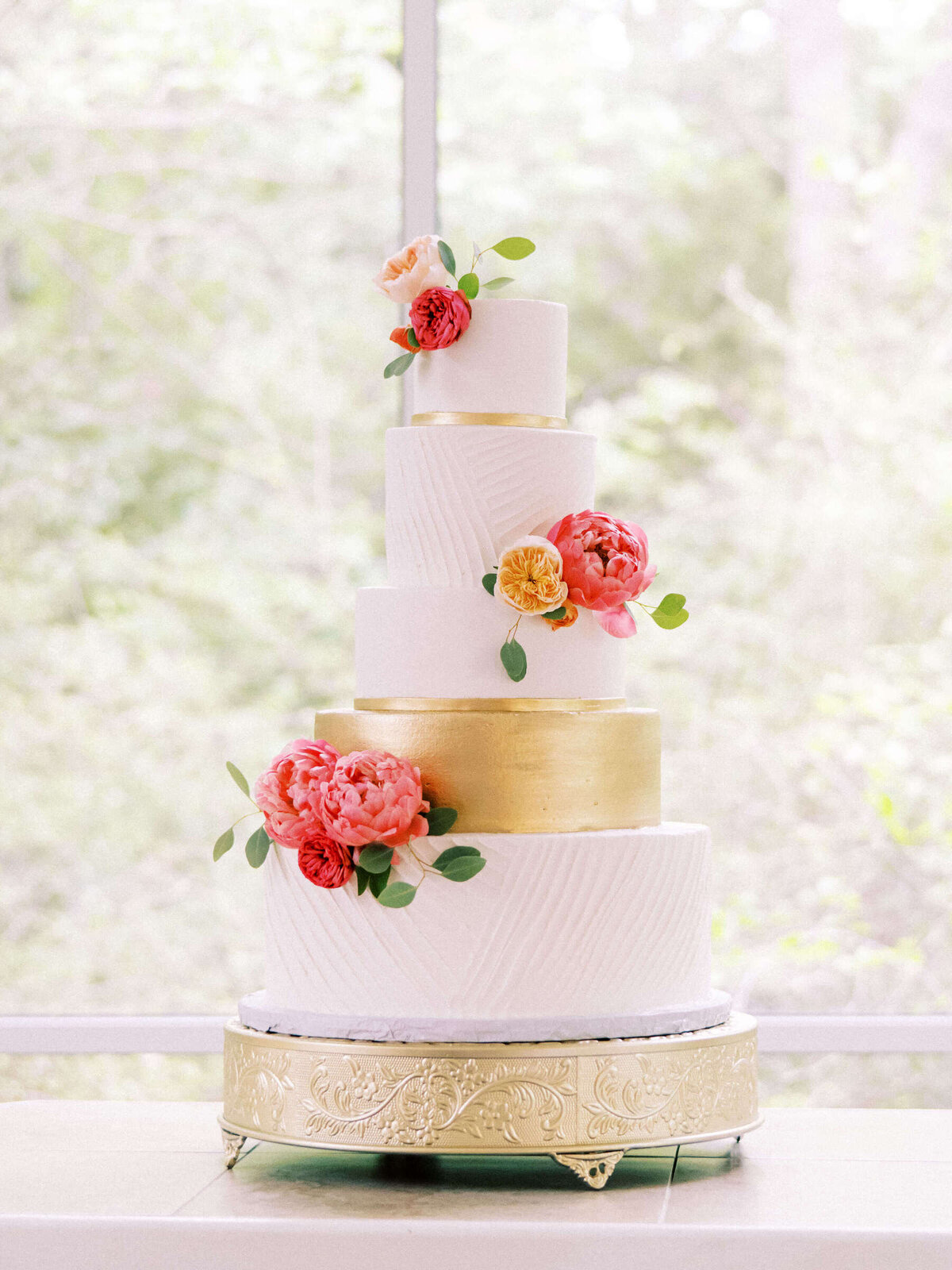 Modern white and gold wedding cake with vibrant peonies at Dallas wedding