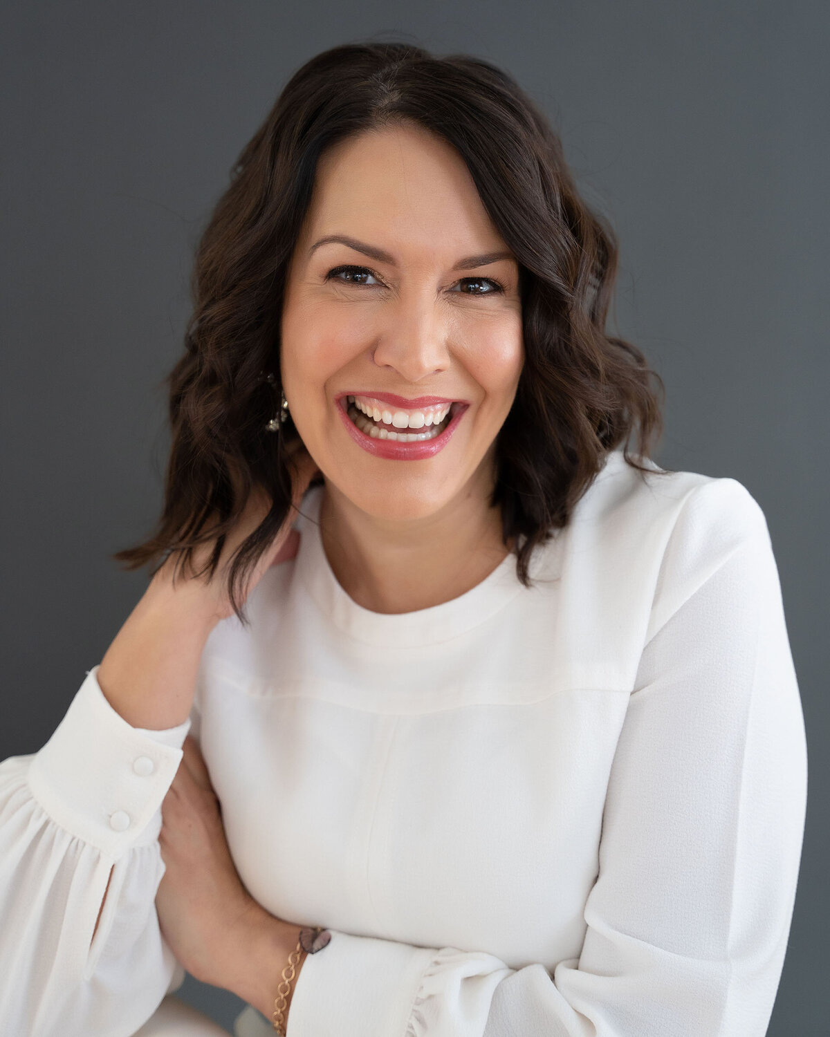 smiling-woman-against-grey-wearing-white