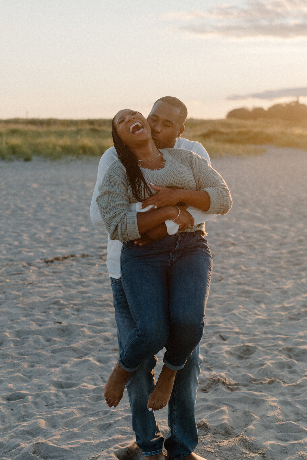man holding woman on beach