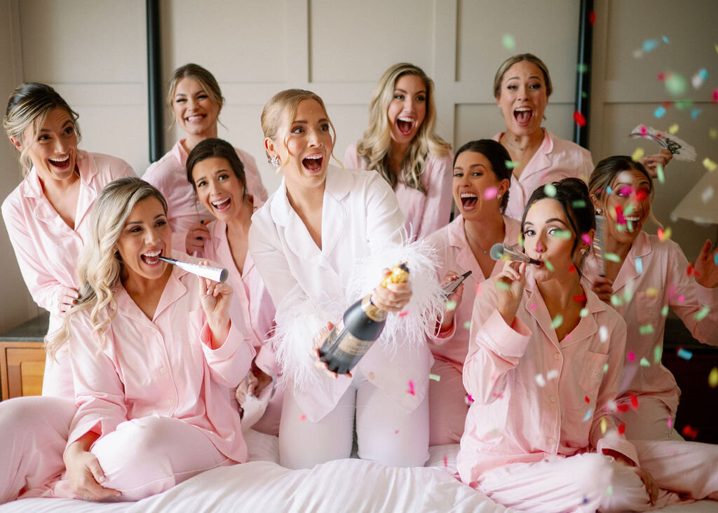 Bride and Bridal Party Popping Champagne