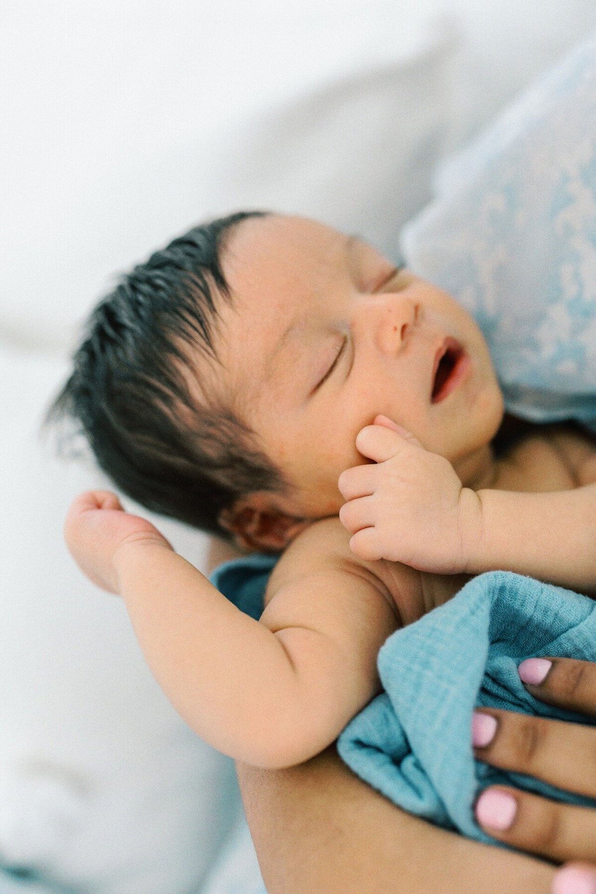 little-boy-newborn-laying-with-arms-out-and-mouth-open