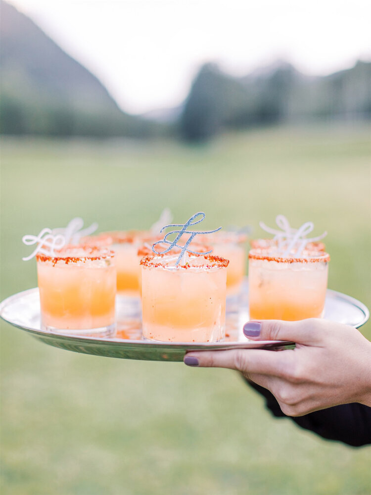 Platter of peach colored cocktails at a mountain wedding