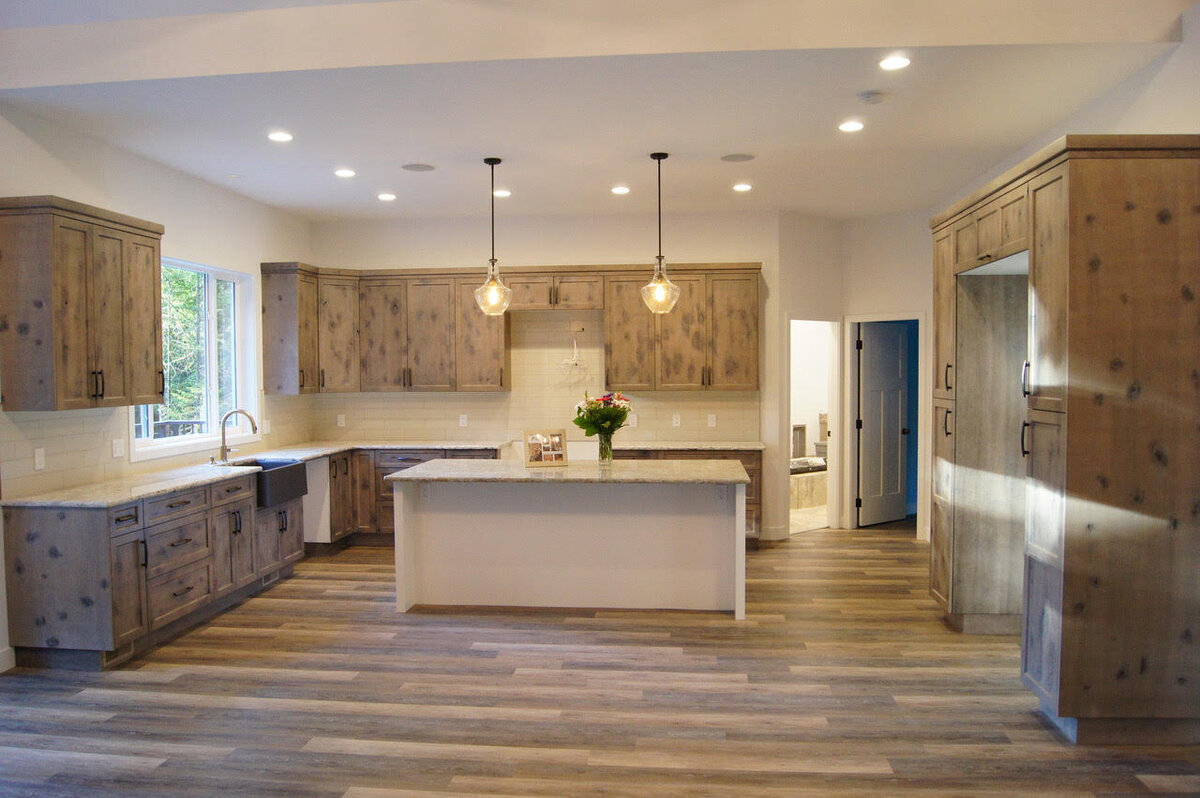 Rustic kitchen design with kitchen island and pendants.
