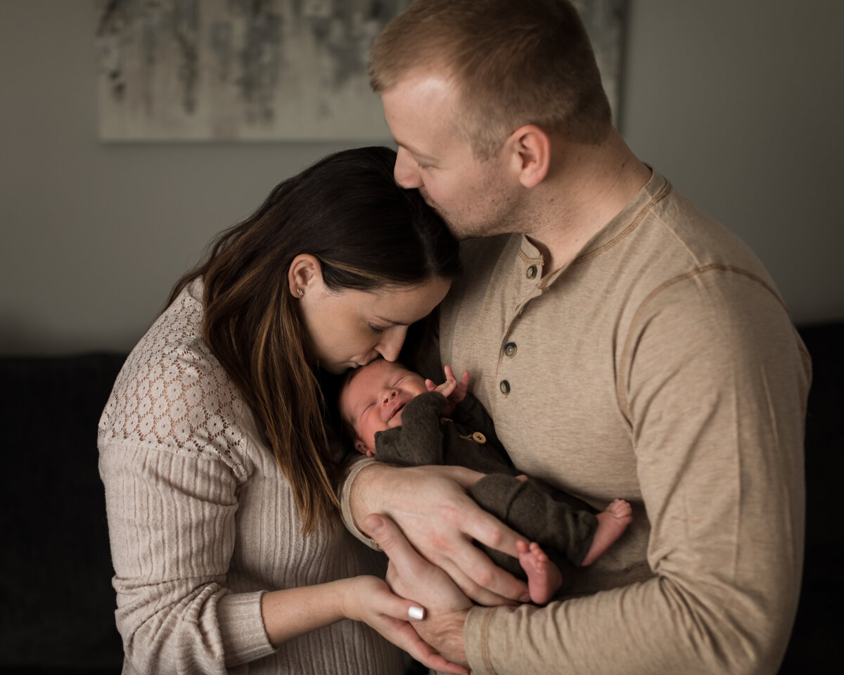 mom and dad holding newborn son for in home lifestyle session