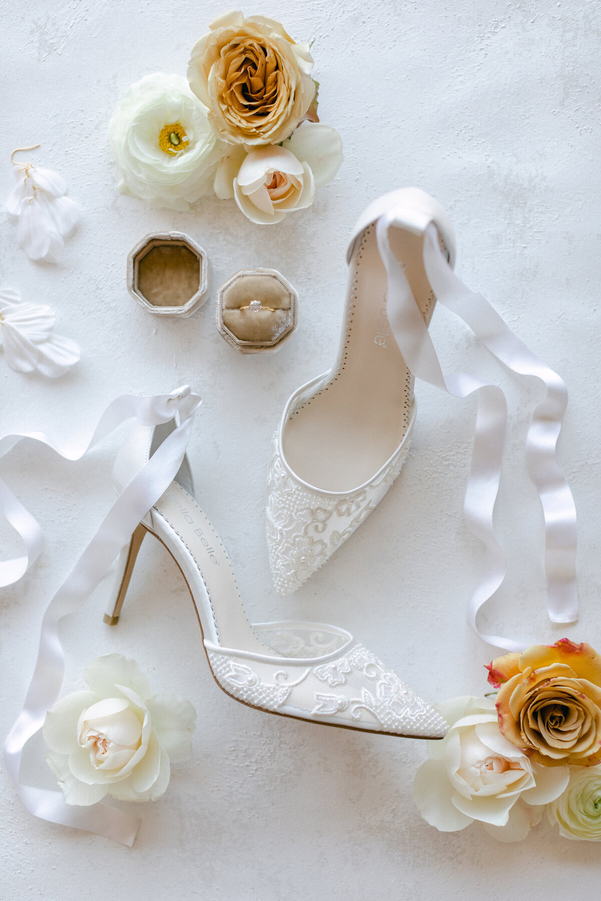 Flatlay of wedding day details - lace heels and wedding rings