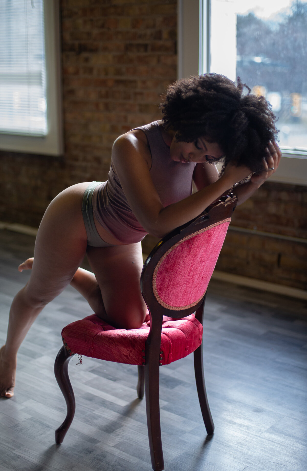 Luxury boudoir photo with a woman in an elegant gown seated on a vintage chair