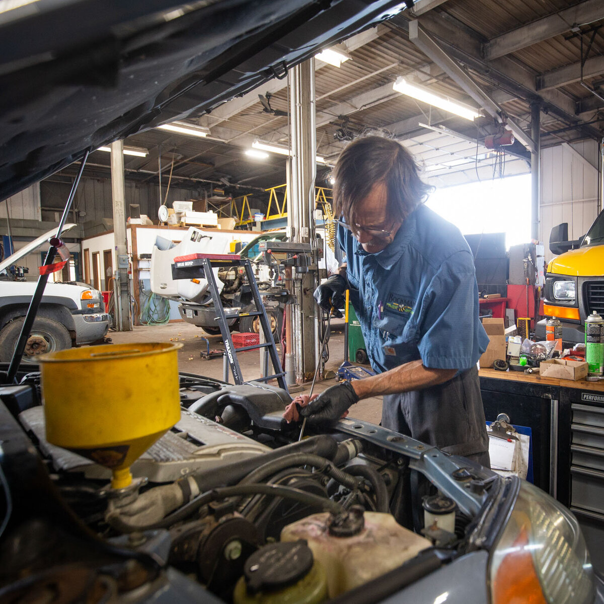 A man is working under the hood of a car