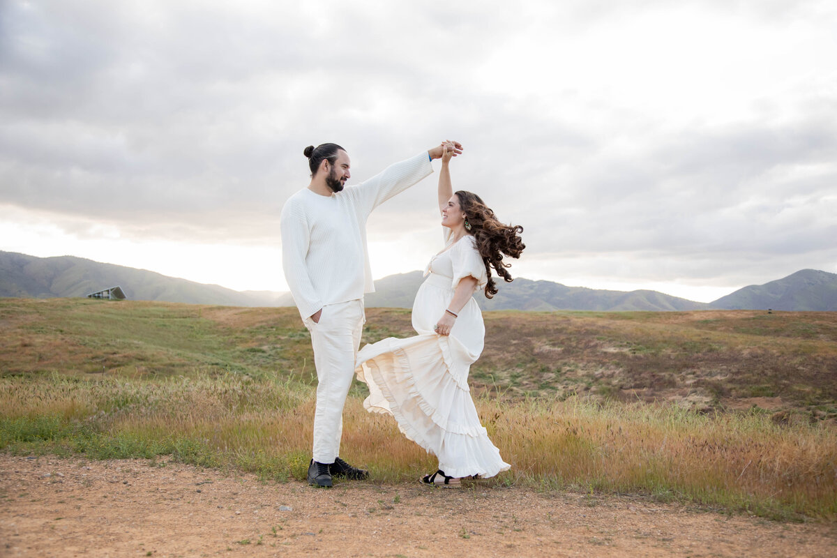 Couple holding hands dancing | California Maternity Session