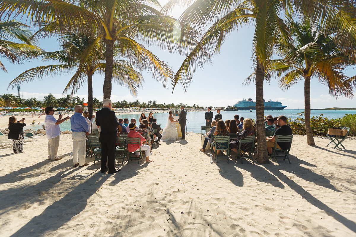 Wide ceremony shot of wedding on castaway cay with Disney Dream in the background
