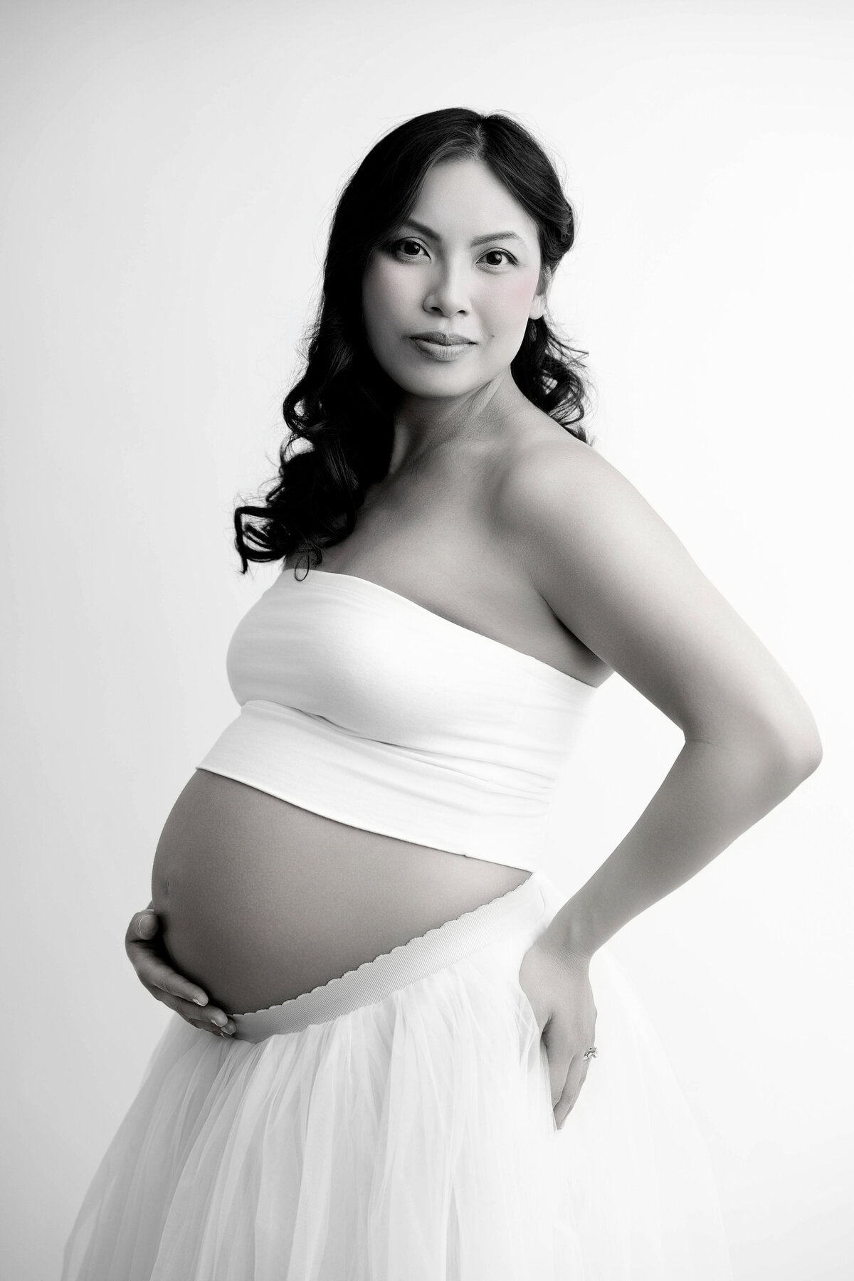 Black and white image of pregnant mom wearing a tube top and skirt.