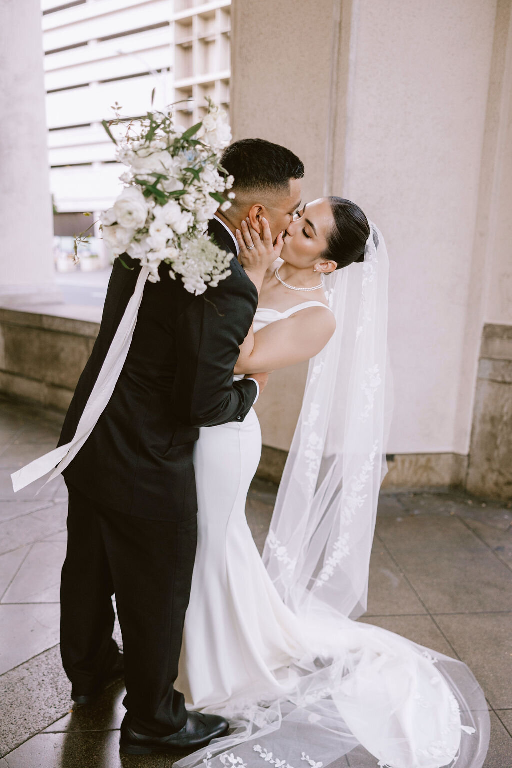 Bride and groom kissing in small classic dip kiss