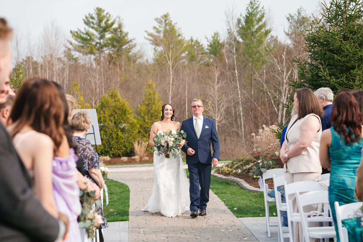 Couple exchanging vows under a floral arch in New England