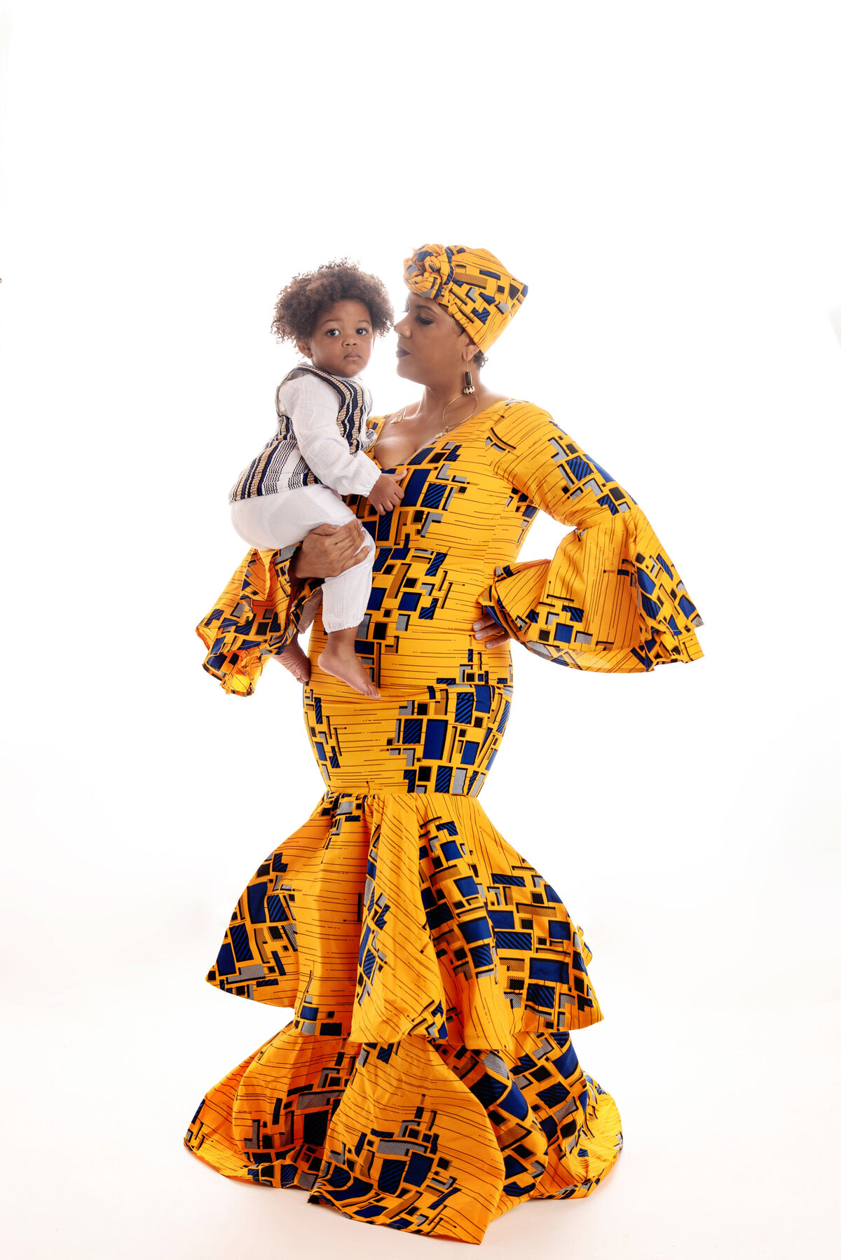 st-louis-family-photographer-mom-wearing-traditional-african-dress-and-head-wrap-holding-boy-wearing-dashiki