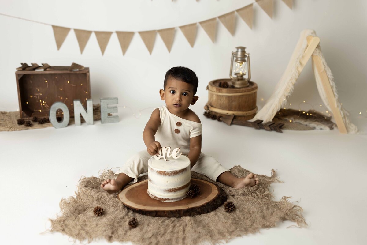 Baby sitting for cake smash about to dig in! Neutral, rustic set decor.